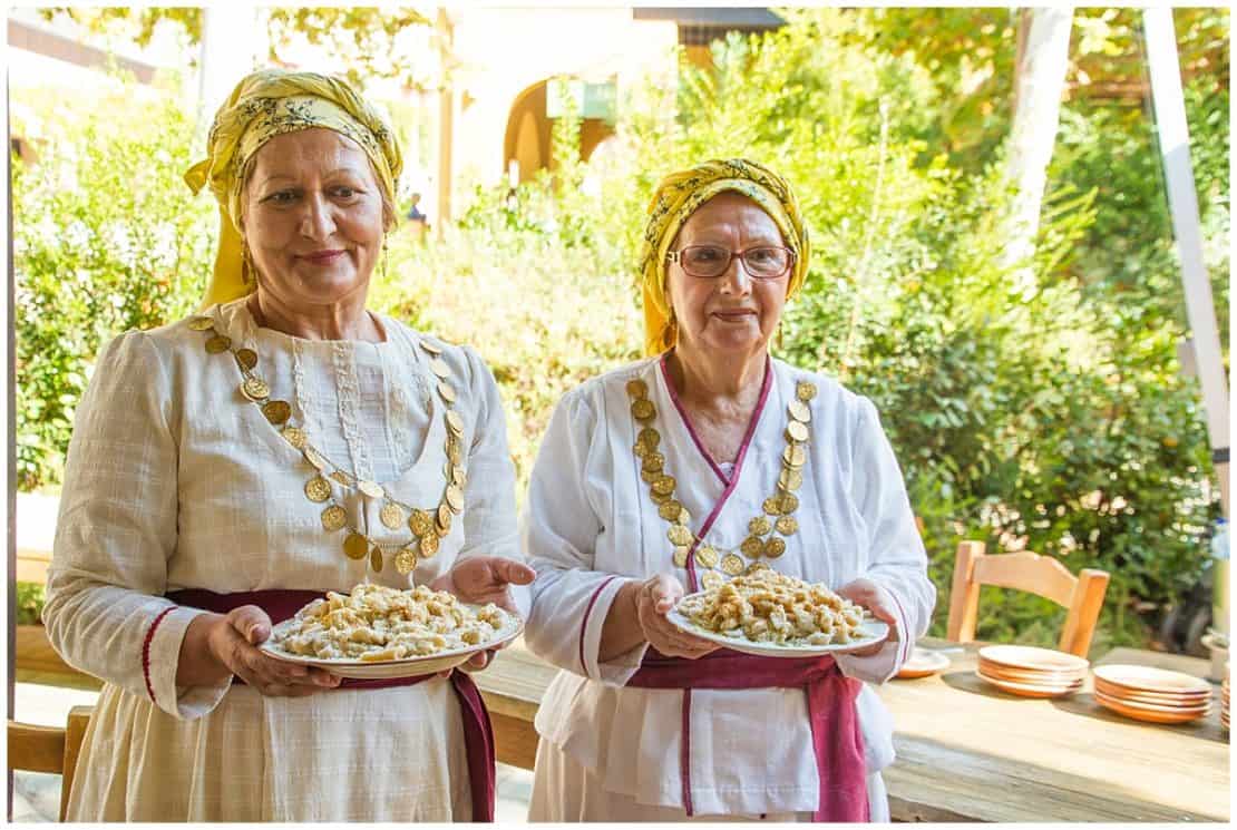 Two Greek women holding food at Costa Navarino in the Peloponnese - Best Peloponnese Itineraries