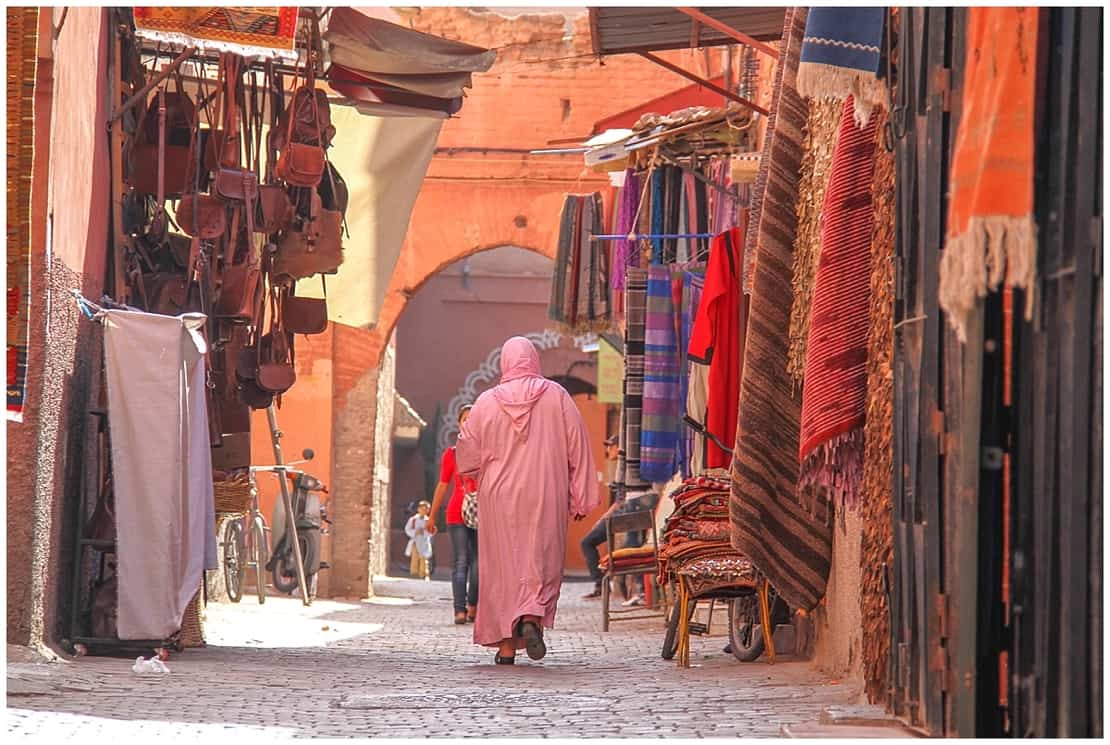 covered woman walks through narrow streets in Marrakech, Morocco - what to pack for Morocco 