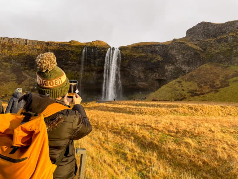 Seljalandfoss-waterfall-in-Iceland-with-woman-taking-photo