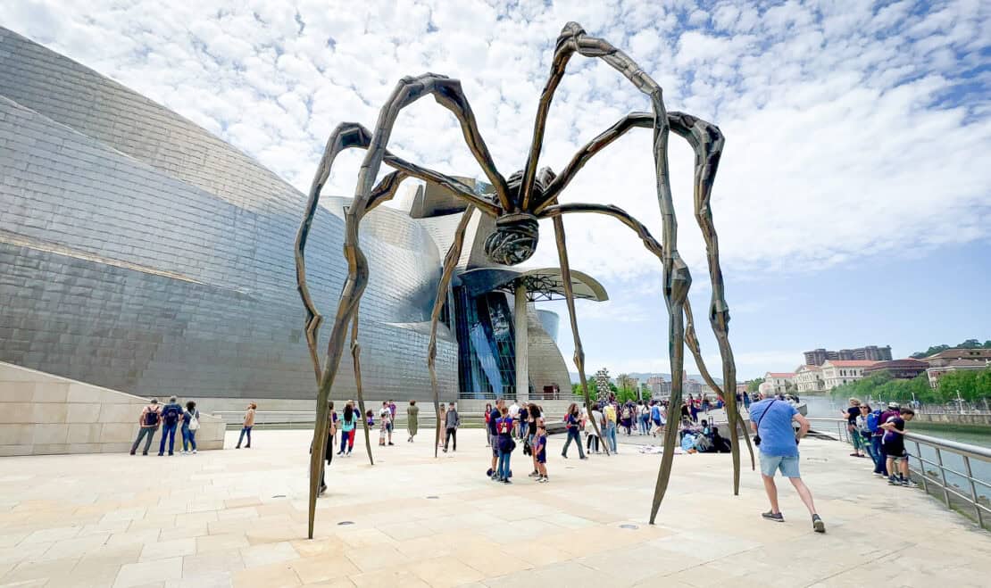 Tourists outside the spider outside the Guggenheim Museum in Bilbao Spain
