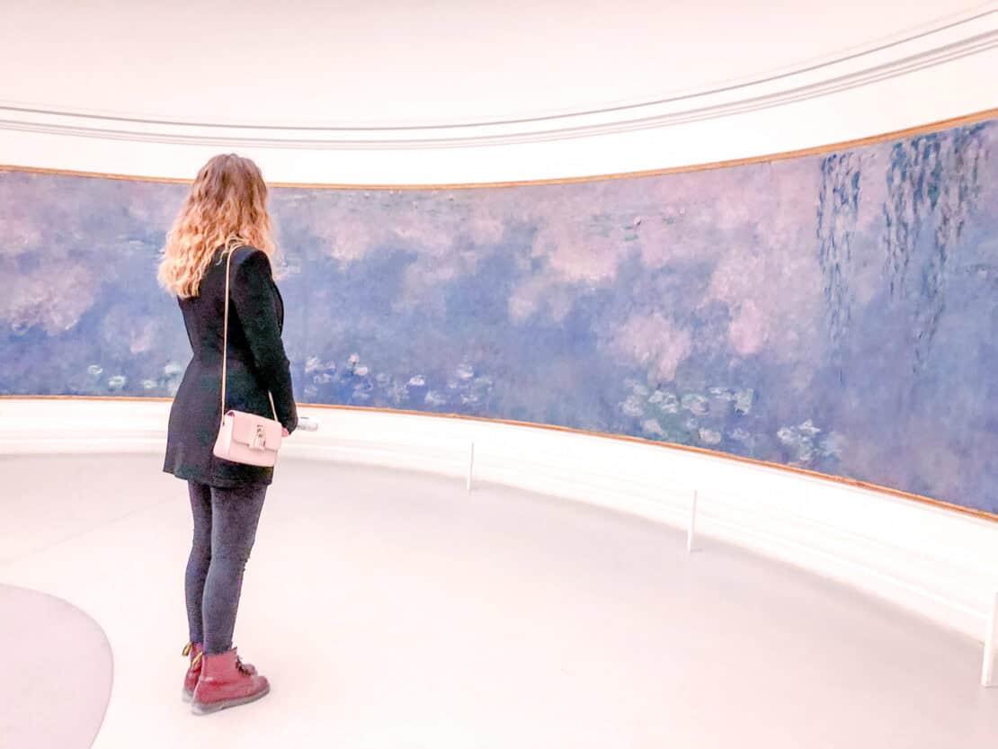 Woman looking at water lilies in the Musee Orangerie Paris