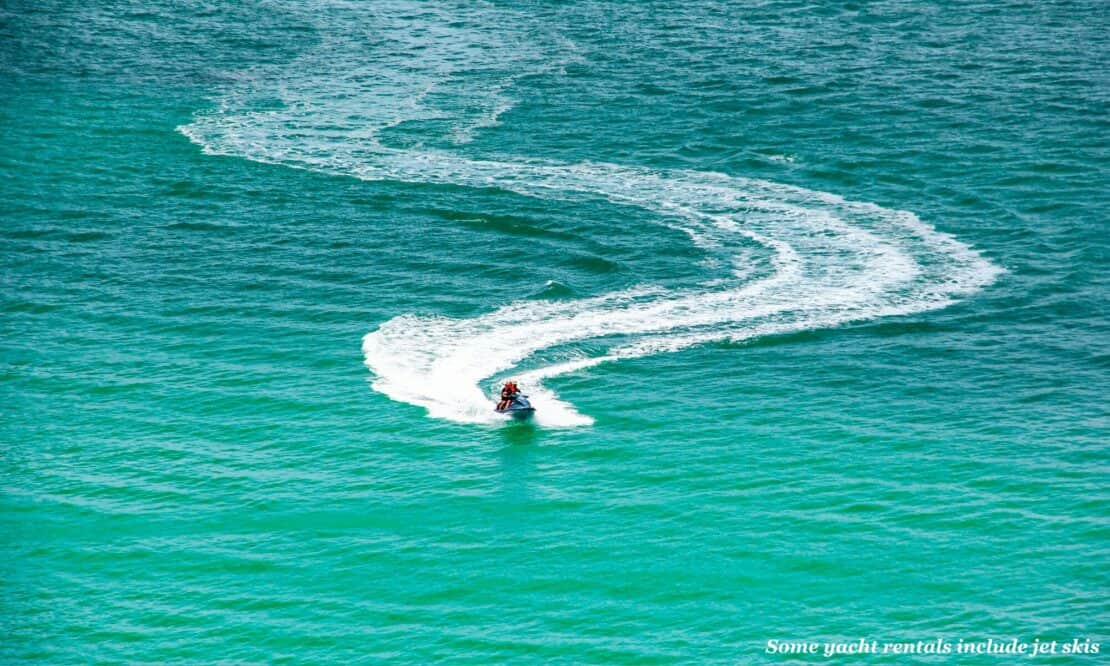 Man carves a path through the blue sea on a jet ski - best yacht rental deals 