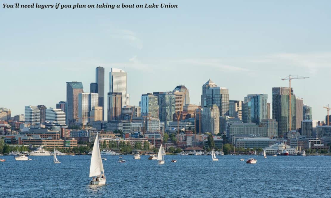 Boats sailing on Lake Union with the Seattle skyline behind them - is Seattle worth visiting 