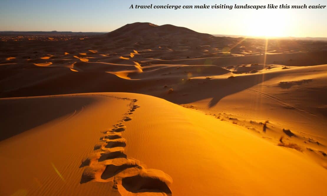 footprints in the sand in a desert at sunset - luxury travel tips